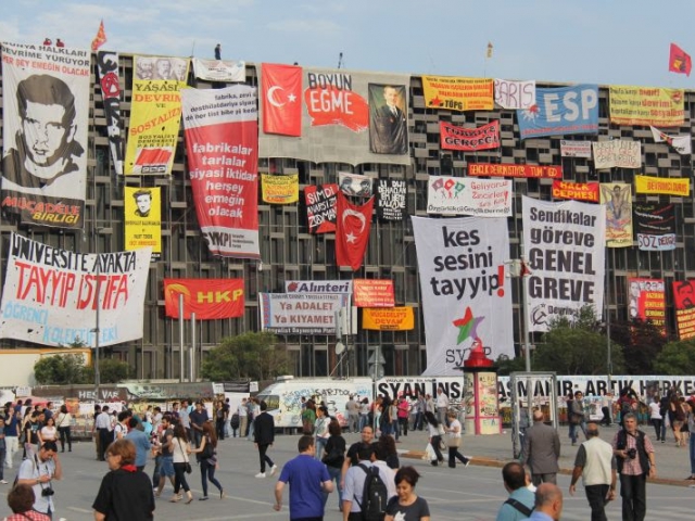 One of the iconic frames taken during the Gezi Park Resistance in Istanbul in 2013. Some of the slogans written on the banners on the building, Ataturk Cultural Center, are as follows: "The university is standing, "Tayyip resign." "Shut up, Tayyip." "Unions to duty, general strike" and “Do not obey.”